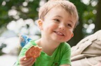lächelnder Junge mit Keks in der Hand