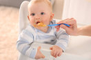 Baby isst von Plastiklöffel