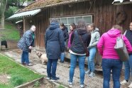 Personengruppe neben einem Holzgebäude im Freien