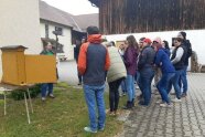 Personengruppe schaut in einen Bienenstock